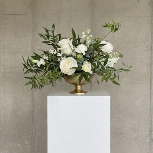 Minimalist white rose and greenery in a white ceramic cylinder.